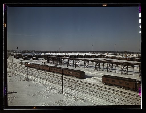 The freight house at a Chicago and Northwestern Railroad yard. In the foreground are old cars used as living quarters for some yard workers and itinerant help; Chicago, Ill.