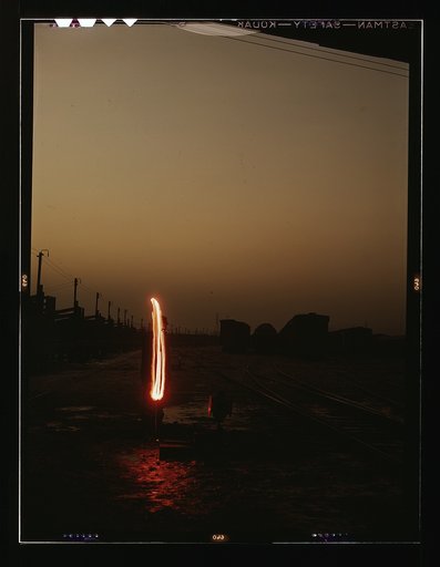 Indiana Harbor Belt RR, switchman demonstrating signalwith a "fusee"- used at twilight and dawn - when visibility is poor. This signal means "go ahead." Calumet City, Ill.