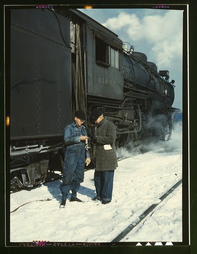 Atchison, Topeka, and Santa Fe railroad conductor George E. Burton and engineer J.W. Edwards comparing time before pulling out of Corwith railroad yard for Chillicothe, Illinois; Chicago, Ill.