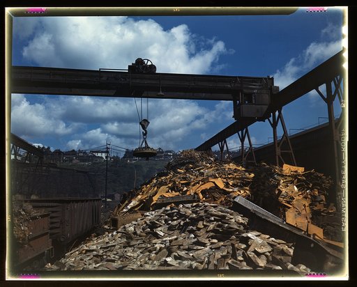 Back into production go these carloads of scrap metal, Allegheny Ludlum Steel[e] Corp., Brackenridge, Pa. The melting of alloy steels for defense work requires that steel mill scrapyards such as this be constantly filled. The overhead magnet deposits the scrap in a loader which carries it to the ope