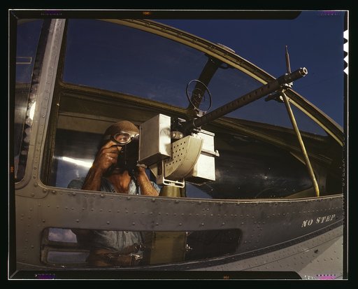 Jesse Rhodes Waller, A.O.M., third class, tries out a 30-calibre machine gun he has just installed in a Navy plane, Naval Air Base, Corpus Christi, Texas