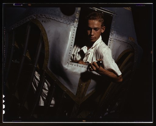Working inside the nose of a PBY, Elmer J. Pace is learning the construction of Navy planes, Corpus Christi, Texas. As an NYA trainee at the Naval Air Base, he gets practical experience. After about eight weeks, he will go into civil service as a sheet metal worker
