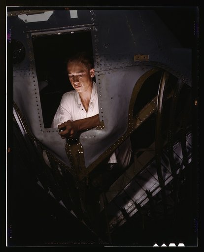 As an NYA trainee working inside the nose of a PBY, Elmer J. Pace is learning the construction of Navy planes, Corpus Christi, Naval Air Base, Texas