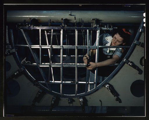 Helen Bray, who left school to become a mechanic at a western aircraft plant, is making an emplanage section on a new Consolidated transport, Consolidated Aircraft Corp., Fort Worth, Texas. This new ship, adapted from the B-24 bomber, is known as the C-87, carries one of the greatest human and cargo