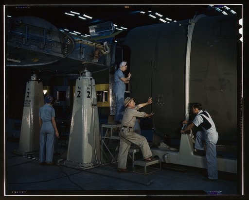 Putting the nose section of a mighty transport plane in place in the fuselage mating fixture at the Consolidated Aircraft Corporation plant, Fort Worth, Texas