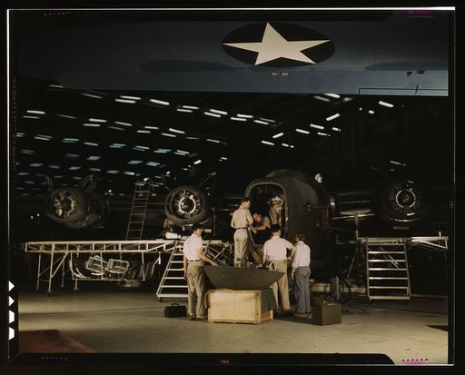 Getting a nose door ready to put on a C-87 transport plane at the end of the assembly line at the Consolidated Aircraft Corporation plant, Fort Worth, Texas