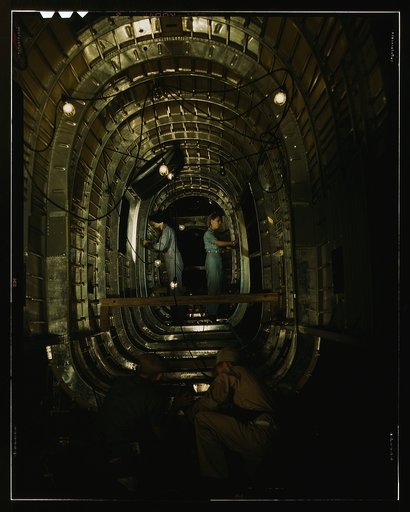 Installing structural parts of a C-87 transport plane in the tunnel of a tail fuselage section at the Consolidated Aircraft Corporation plant, Fort Worth, Texas