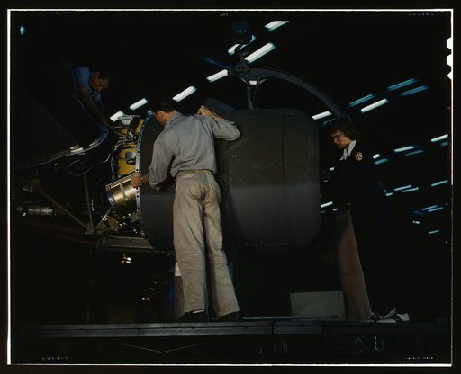 Lowering an engine in place in assembling a C-87 transport plane at the Consolidated Aircraft Corporation plant, Fort Worth, Texas