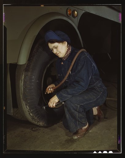 War production workers at the Heil Company making gasoline trailer tanks for the U.S. Army Air Corps., Milwaukee, Wisconsin. Mrs. Angeline Kwint, age 45, an ex-housewife, checking the tires of trailers. Her husband and son are in the U.S. Army