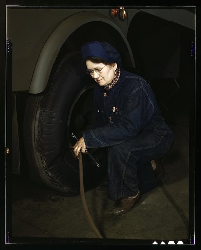 War production workers at the Heil Company making gasoline trailer tanks for the U.S. Army Air Corps, Milwaukee, Wis. Mrs. Angeline Kwint, age 45, an ex-housewife, checking the tires of trailers. Her husband and son are in the U.S. Army