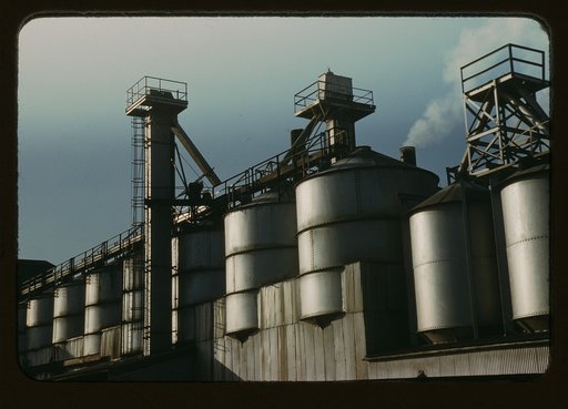 Section of the batch house at a plant of the Owens-Corning Fiberglas Corporation, Toledo, Ohio. In the bins are stored the raw materials for the batch from which fiberglass materials vital to the war effort are produced