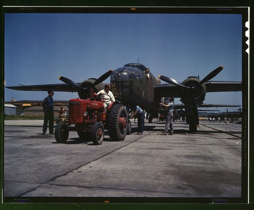B-25 bomber planes at the North American Aviation, Incorporated being hauled along an outdoor assembly line with an "International" tractor, Kansas City, Kansas