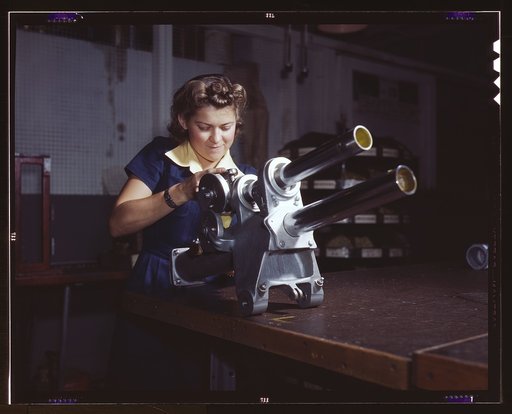 A young woman employee of North American Aviation, Incorporated, working over the landing gear mechanism of a P-51 fighter plane, Inglewood, Calif. The mechanism resembles a small cannon