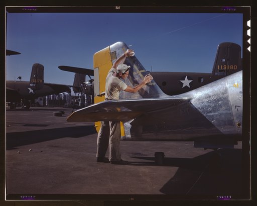 On North American's outdoor assembly line, a painter cleans the tail section of a P-51 fighter prior to spraying the olive-drab camouflage of the U.S. Army, N[orth] A[merican] Aviation, Inc., Inglewood, Calif.