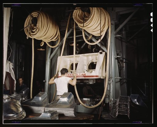 Huge drop hammers work day and night forming sheet metal parts for United Nations bombers and fighters at the North American Aviation, Inc., plant, Inglewood, Calif. The heavy hemp rope is used to snub the hammer so that it forms the part under proper pressure and rises clear of the work after each 