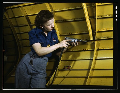 Operating a hand drill at Vultee-Nashville, woman is working on a "Vengeance" dive bomber, Tennessee
