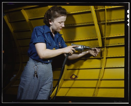 Operating a hand drill at Vultee-Nashville, woman is working on a "Vengeance" dive bomber, Tennessee