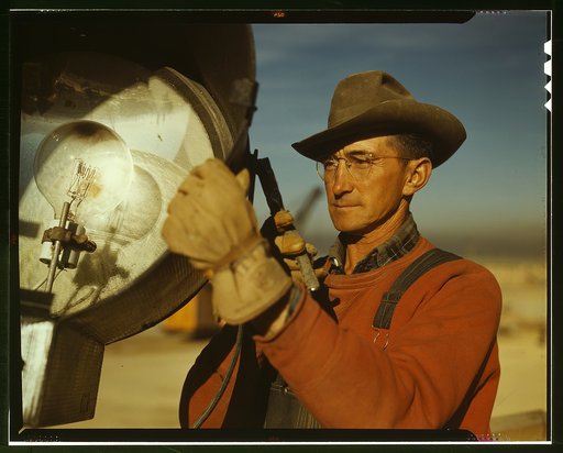Servicing one of the floodlights that turn night into day at the big construction operations for a new steel plant which will make important additions to the vast amount of steel needed for the war effort, Columbia Steel Co., Geneva, Utah