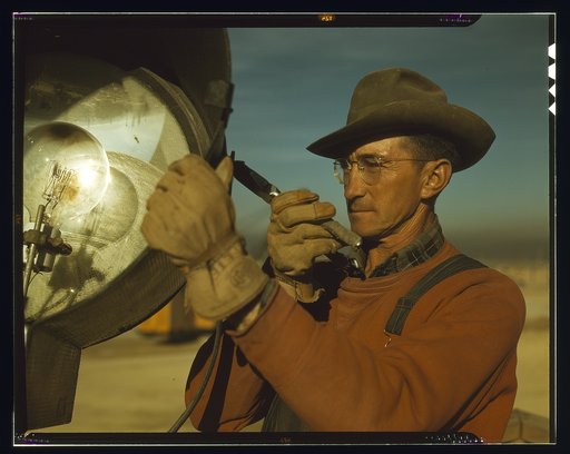 Servicing one of the floodlights that turn night into day at the big construction operations for a new steel plant which will make important additions to the vast amount of steel needed for the war effort, Columbia Steel Co., Geneva, Utah