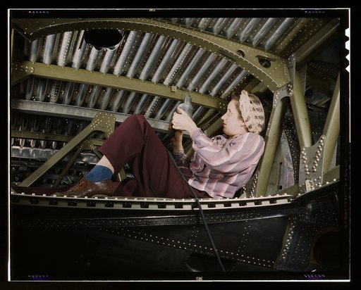 An A-20 bomber being riveted by a woman worker at the Douglas Aircraft Company plant at Long Beach, Calif.