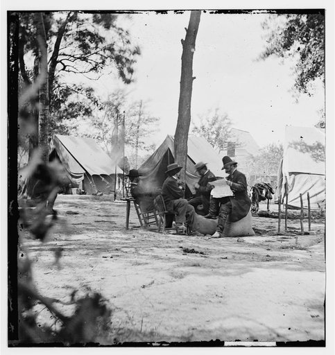 Gen. Ambrose E. Burnside (reading newspaper) with Mathew B. Brady (nearest tree) at Army of the Potomac headquarters