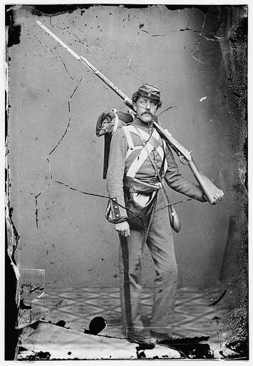 Unknown location. Unidentified Union volunteer with shouldered rifle and bayonet in photographer's studio