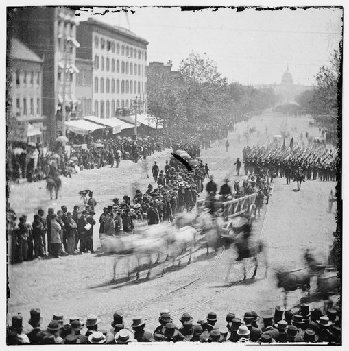 Washington, District of Columbia. Grand Review of the Army. Infantry unit with fixed bayonets followed by ambulances passing on Pennsylvania near the Treasury