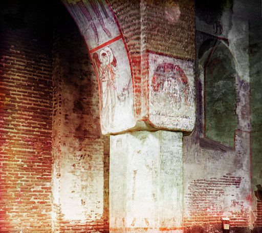 Interior showing exposed brick and column with murals