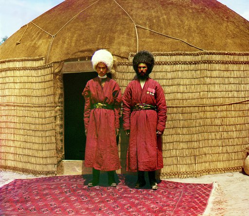 Two men standing on a rug, in front of yurt