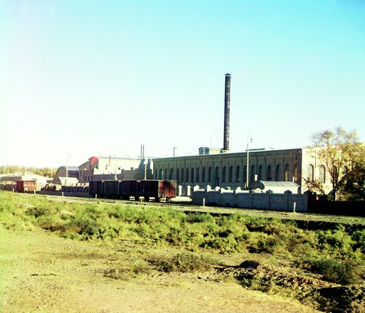 Railroad tracks and cars in front of a factory(?)