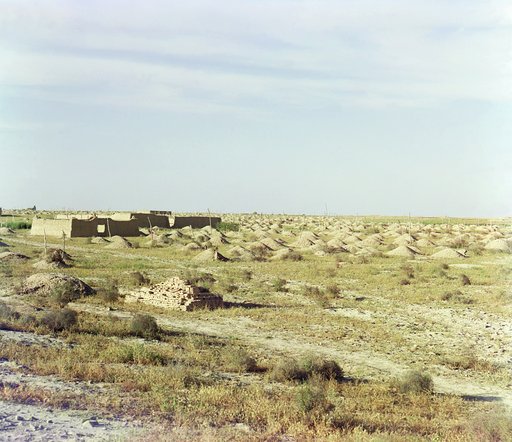 Adobe buildings and burial mounds in desert area