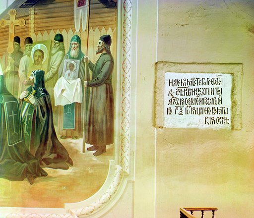 Sign on wall, adjacent to religious mural