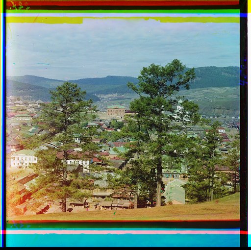 City scene through trees, mountains in background