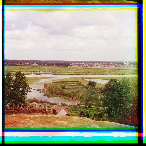 View of a settlement, croplands, and a forest, near a river