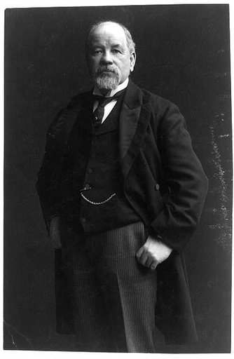 Thomas Burke, candidate to succeed Piles as senator, three-quarter length portrait, standing, facing left, thumbs in his pants pockets