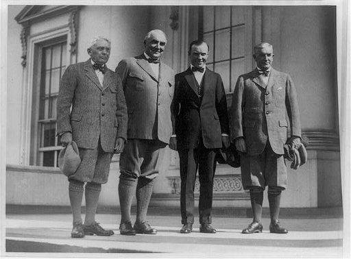 Group portrait of, standing left to right: Frank Billings Kellogg, Warren G. Harding, Chick Evans (a golfer), and Henry Prather Fletcher; three are wearing knickers
