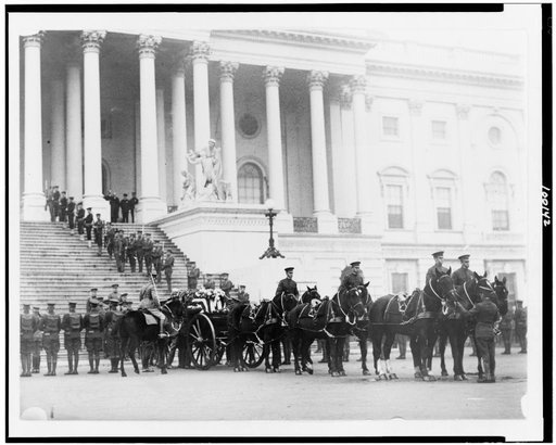 Flag-draped casket of the unknown soldier on horsedrawn caisson in front of the U.S. Capitol
