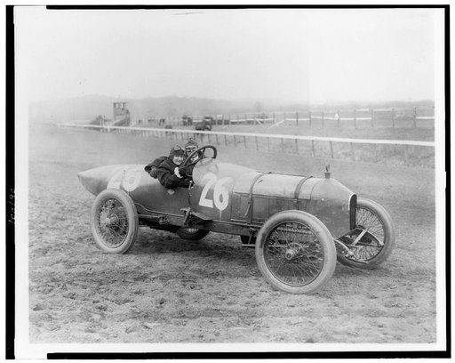 Side view of man and woman in Stutz Weightman Special no. 26 on Benning race track, Washington, D.C., area