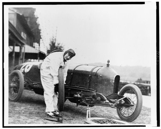 Woman changing tire of Stutz Weightman Special no. 26 on Benning race track, Washington, D.C., area
