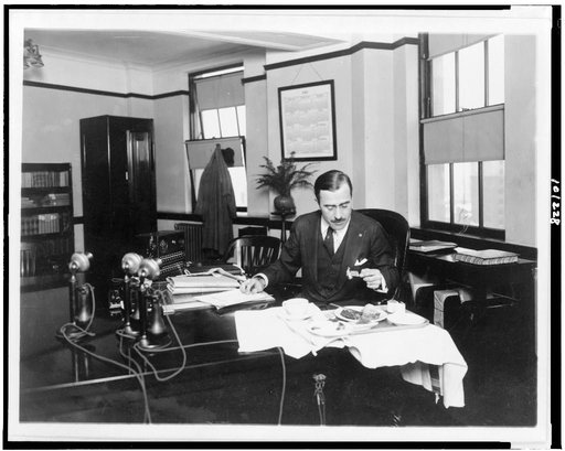 R.G. Cholmeley-Jones, Director of the War Risk Bureau, eating lunch at his desk