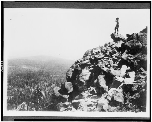 Man looking out from rocky cliff side in a northwest national park(?)