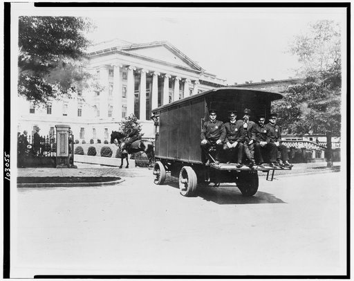 Five policemen sitting on back of van and policeman on horseback; outside south side of the Treasury Building, Washington, D.C.