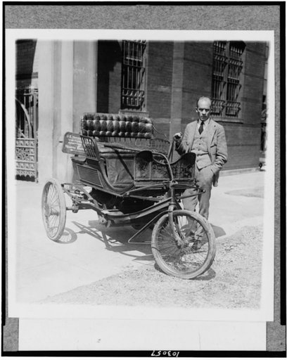 Carl W. Mitman, Curator of Engineering of the Smithsonian Institution photographed with a three-wheel automobile which has been recently acquired by that institution--This old auto in 1909 won first prize in a parade in New York as the oldest vehicle running under its own power
