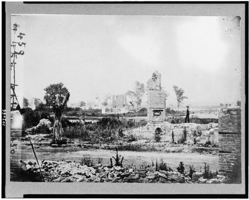 Ruins at Hampton, Virginia showing chimneys, and man standing