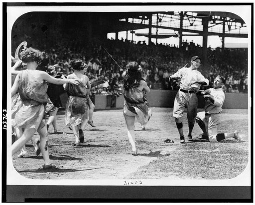 Women dancing and two Washington National baseball players clowning on baseball field