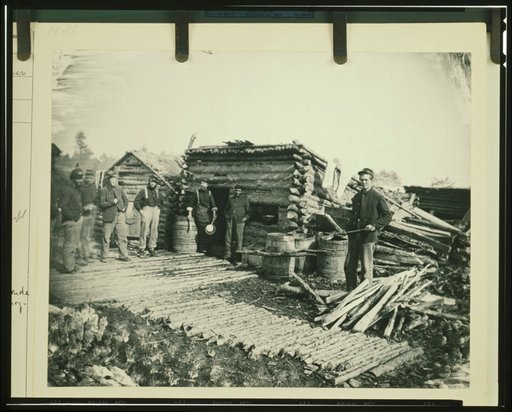 Civil War camp of the 6th N.Y. Artillery at Brandy Station, Virginia, showing Union soldiers in front of log company kitchen