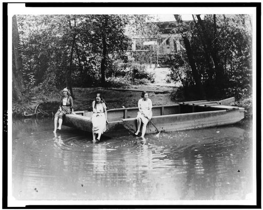 Three women sitting on scow in Rock Creek Park, Washington, D.C.