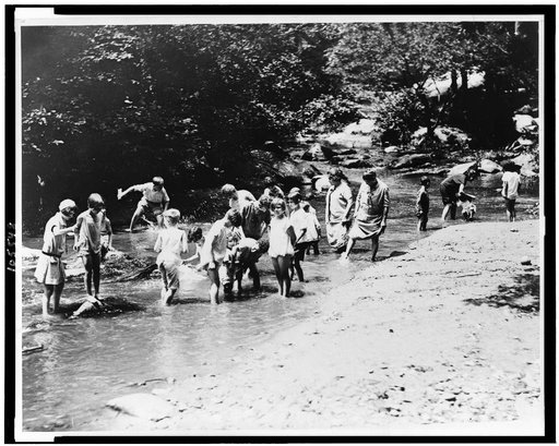 On one of the hottest days recorded in the National Capital both women and children rush to the water for relief. Snapped in Rock Creek Park