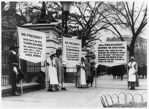 People dressed as pilgrims carrying three signs for amnesty for political prisoners standing in front of the White House