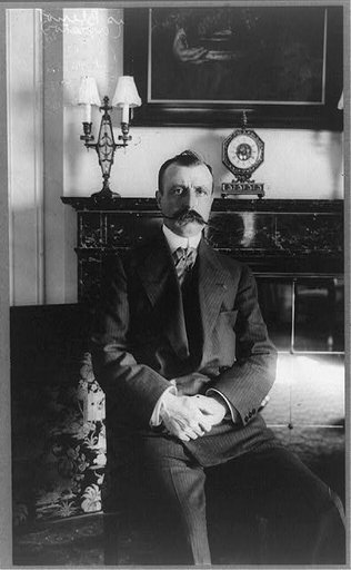 Louis Blériot, three-quarter length portrait, seated, facing front